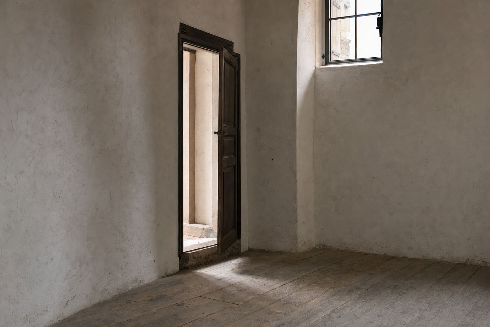 Cuarto cerrado, puerta entreabierta y umbral de piedra.