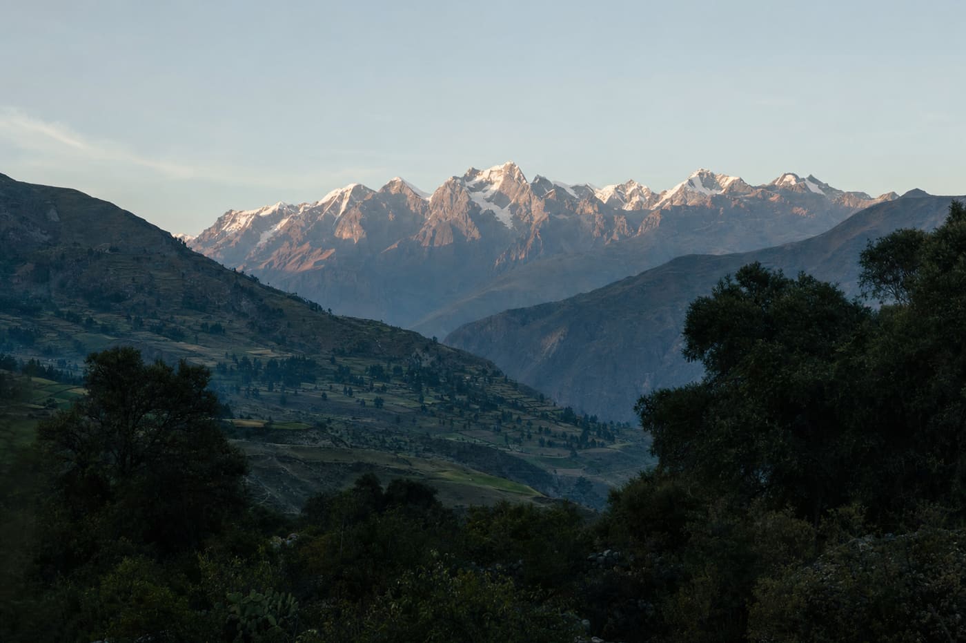 Cordillera al final de la tarde, valle en verde.