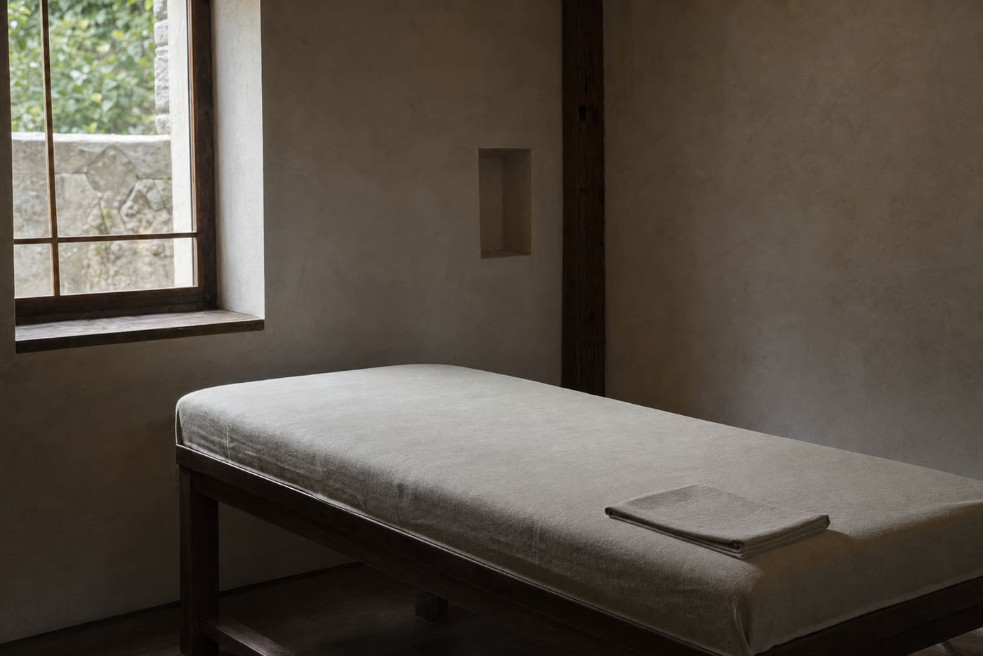 Cama de trabajo con lino tensado y luz de ventana.